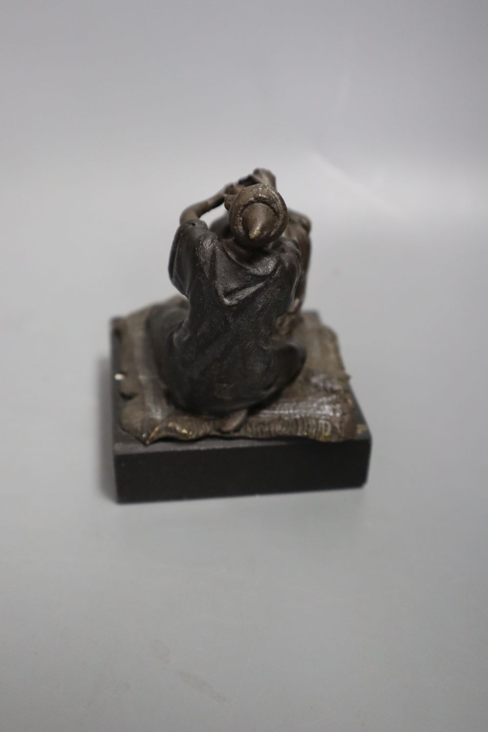 A cast metal sculpture Kiss after Rodin, height 14cm and another of Arabs